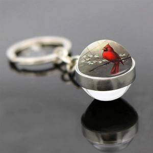 Detailed macro view of the cardinal bird glass ball pendant with silver metal keyring