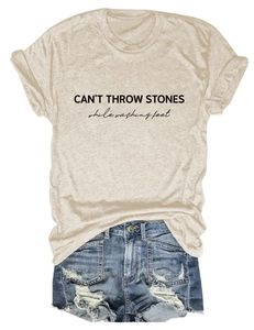 Detail of CAN'T THROW STONES print on beige t-shirt paired with frayed denim shorts