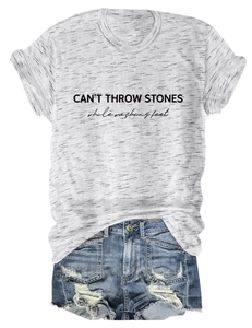 Detailed flat lay of light grey T-shirt with black text print and distressed denim shorts