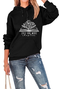Detail of Just One More Chapter lettering and floral print on a black hooded sweatshirt