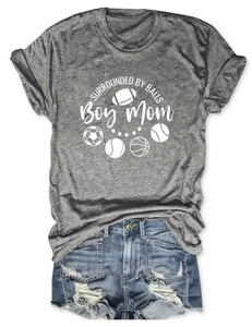 Flat lay of gray Boy Mom tee with sports ball icons and distressed denim shorts