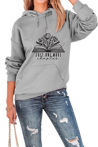 Detail of grey hoodie with book floral print and Just One More Chapter text design