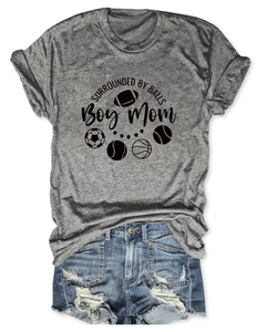 Detail of grey Boy Mom t-shirt with sports ball icons and distressed denim shorts