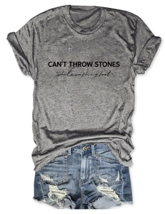 Detailed flat lay of a grey t-shirt with letter print and distressed blue denim shorts