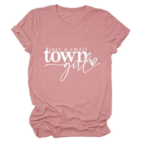 Détail d'un t-shirt rose avec l'inscription blanche Just a Small Town Girl et motif cœur