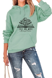 Detail of mint green hoodie with Just One More Chapter book and floral print design
