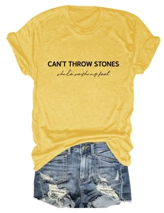 Detail of yellow cotton tee with black slogan print and distressed denim shorts texture