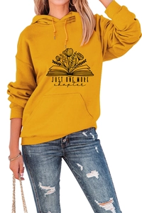 Close-up of 'Just one more chapter' book floral print on yellow hooded sweatshirt