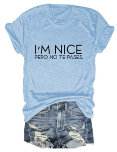 Detail of I'M NICE PERO NO TE PASES slogan print on light blue tee and denim shorts