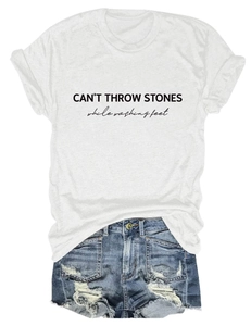 Detail of CAN'T THROW STONES print on white t-shirt with distressed denim shorts