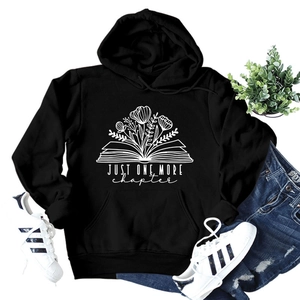 Close-up of floral book print and Just One More Chapter text on black hoodie fabric