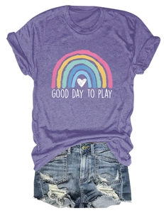 Posa piatta di maglietta viola con stampa arcobaleno e pantaloncini di jeans usurati