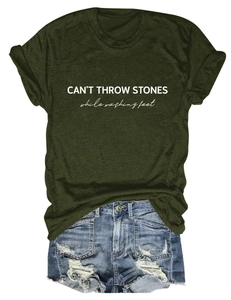 Close-up of olive green T-shirt with CAN'T THROW STONES print and ripped denim shorts