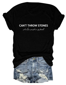 Detail of CAN'T THROW STONES white letter print on a casual black cotton t-shirt