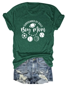 Detail of dark green Boy Mom T-shirt featuring sports balls and casual denim shorts