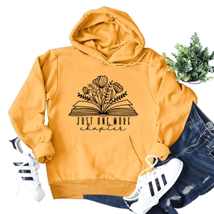 Flat lay of yellow hoodie with floral book art and 'Just One More Chapter' text design