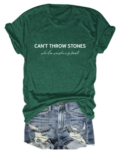 Detail view of dark green t-shirt with letter print and distressed denim shorts