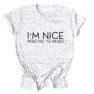 Close-up of I'M NICE PERO NO TE PASES text print on heather grey cotton t-shirt