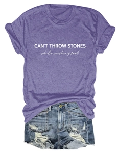 Detail of CAN'T THROW STONES letter print on purple cotton t-shirt with distressed denim