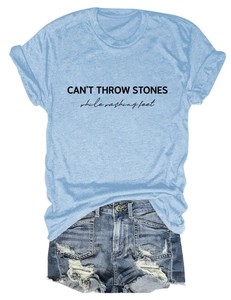 Close-up of blue T-shirt with CAN'T THROW STONES print and frayed denim shorts