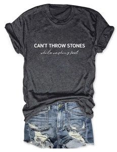 Detail of CAN'T THROW STONES text print on charcoal grey tee and distressed denim shorts