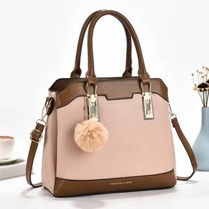 Detailed shot of leather crossbody bag with pink and brown color block and gold hardware