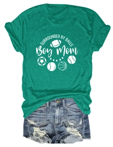 Flat lay of green Boy Mom t-shirt with sports icons and distressed denim shorts