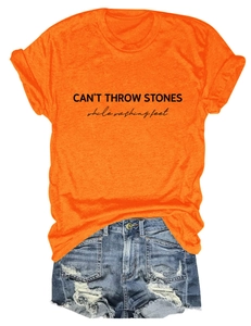 Detail of orange crew neck t-shirt with black CAN'T THROW STONES letter printing