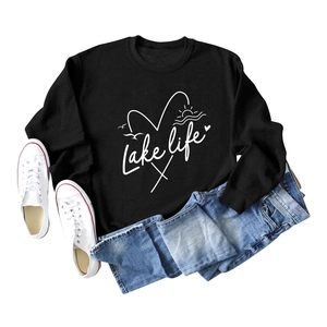Flat lay of black Lake Life sweatshirt with blue jeans and white canvas sneakers