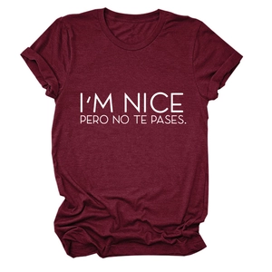 Close-up of burgundy t-shirt with white I'M NICE PERO NO TE PASES printed text