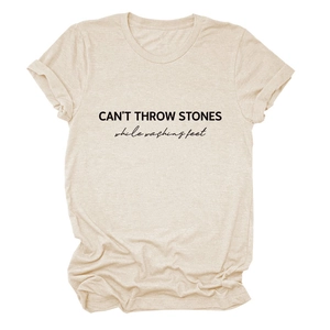 Detail of rolled cuff sleeves and black letter print on beige cotton t-shirt