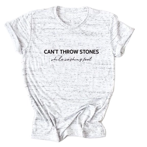 Detail of CAN'T THROW STONES text print on heather grey cotton t-shirt fabric