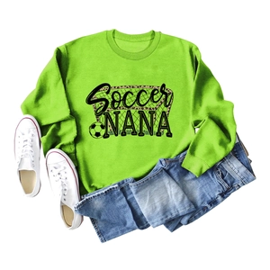 Flat lay of neon green Soccer NANA sweatshirt with denim shorts and white sneakers