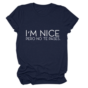 Close-up of I'M NICE PERO NO TE PASES text print on navy blue cotton crewneck t-shirt