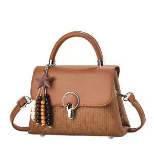 Brown vintage faux leather handbag with velvet texture and round metal buckle detail