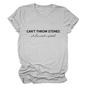 Detail of CAN'T THROW STONES typography on a gray cotton blend crewneck t-shirt