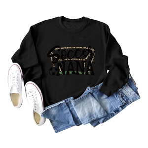 Flat lay of black Soccer NANA sweatshirt with leopard print football graphics and jeans