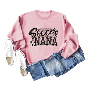 Flat lay of pink Soccer NANA sweatshirt with white canvas shoes and denim shorts