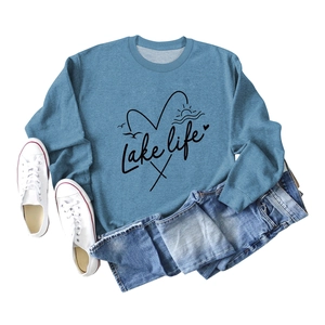 Flat lay of foggy blue Lake Life sweatshirt with artistic print and denim shorts
