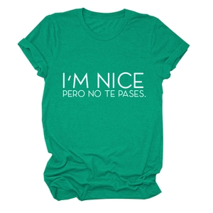 Detail of emerald green t-shirt featuring I'M NICE PERO NO TE PASES white slogan