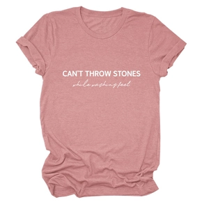 Detail of the white CAN'T THROW STONES print on a pink crew neck short sleeve cotton T-shirt