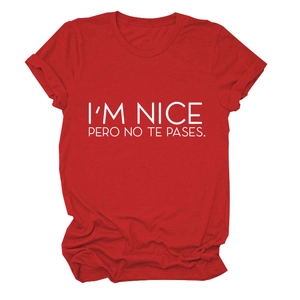 Close-up of I'M NICE PERO NO TE PASES text print on red short sleeve t-shirt fabric