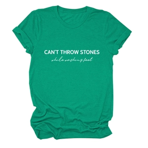 Detail of CAN'T THROW STONES white letter print on a green crew neck cotton t-shirt