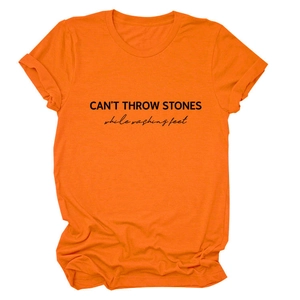 Detail of CAN'T THROW STONES vintage slogan print on bright orange cotton t-shirt