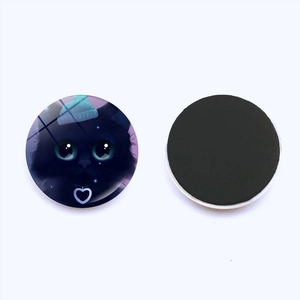 Macro detail of the round black cat fridge magnet with smooth glass dome and soft magnetic back