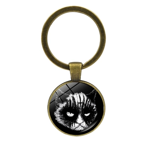 Close-up of bronze cat keychain pendant with gothic feline art and glass cabochon