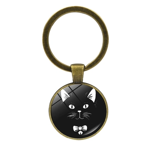 Macro detail of bronze pendant keychain with glass cabochon featuring a black cat design