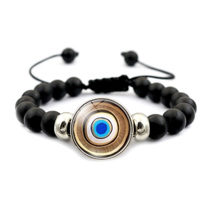 Détail du bracelet en perles noires mates avec œil bleu en verre et cordon de serrage