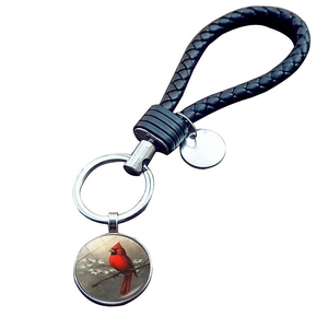 Close-up of a cardinal bird pendant with a black braided leather rope keychain