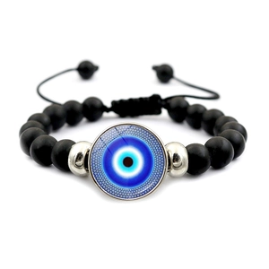 Détail de la breloque œil bleu sur bracelet en perles noires mates avec cordon